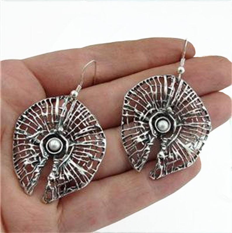 sculptural sterling silver net with a round freshwater Pearl.
