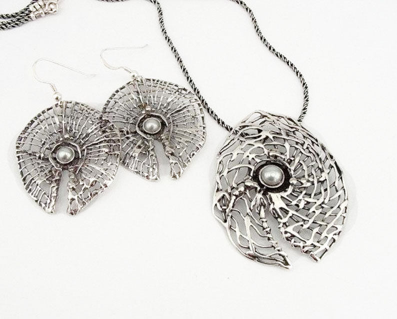 Round sterling silver net pendant with white natural gemstone.