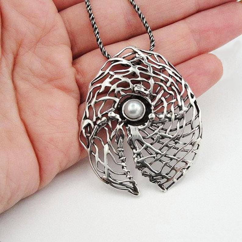 Round sterling silver net pendant with white natural gemstone.