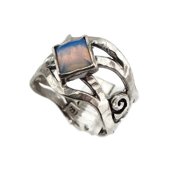 Sterling silver ring with an openwork design, featuring a square 6mm x 6mm Opalite gemstone. The ring’s unique sculptural pattern and solid silver band highlight the luminous, soft blue glow of the Opalite, creating an elegant, artistic piece by Hadar Jewelry