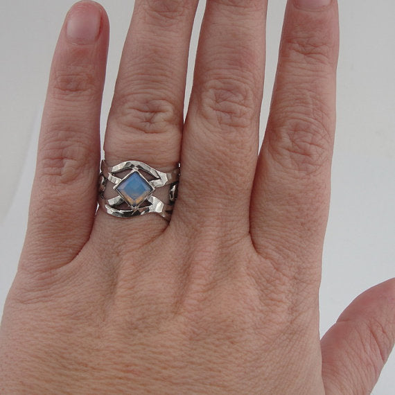Sterling silver ring with an openwork design, featuring a square 6mm x 6mm Opalite gemstone. The ring’s unique sculptural pattern and solid silver band highlight the luminous, soft blue glow of the Opalite, creating an elegant, artistic piece by Hadar Jewelry