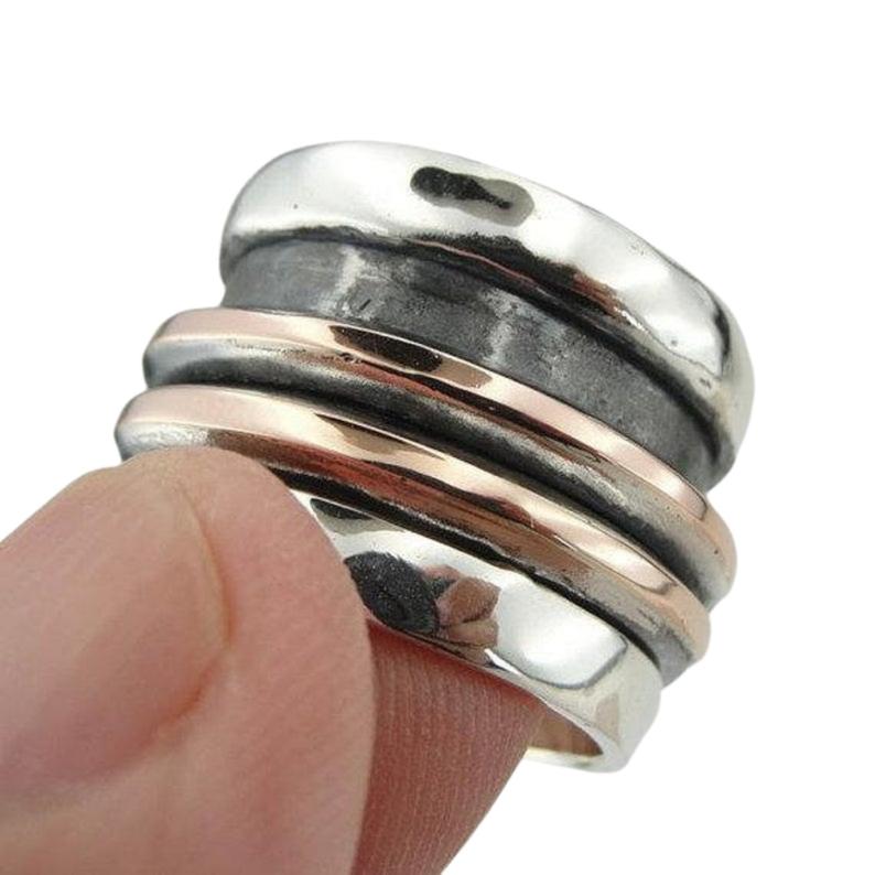 Wide and Swivelling Sterling silver ring, decorated with red gold swivel bands