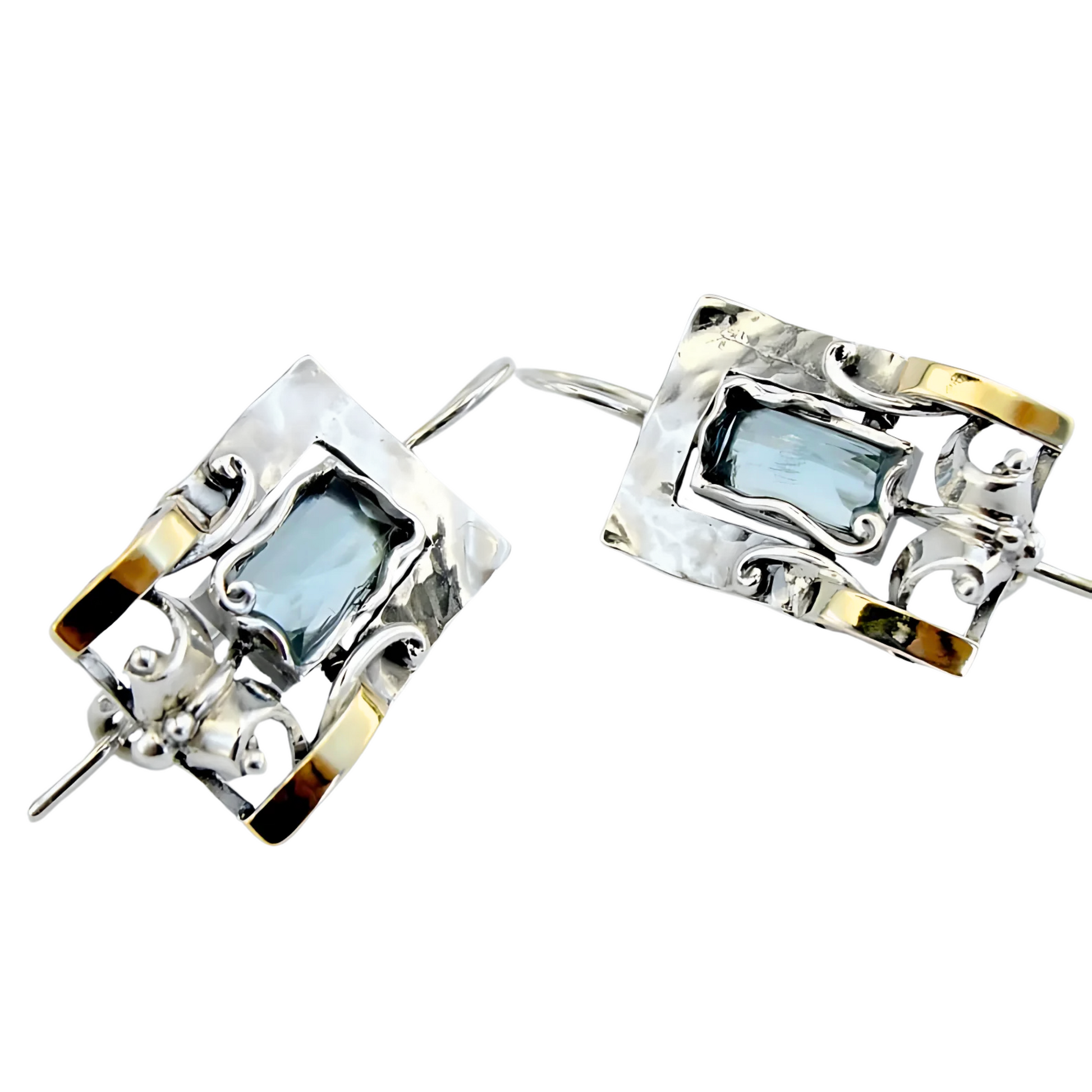 Handcrafted sterling silver earrings featuring a rectangular blue topaz gemstone with elegant yellow gold accents and intricate detailing, designed by Hadar Jewelry. These artisan earrings blend contemporary style with timeless sophistication, perfect for a unique statement look.