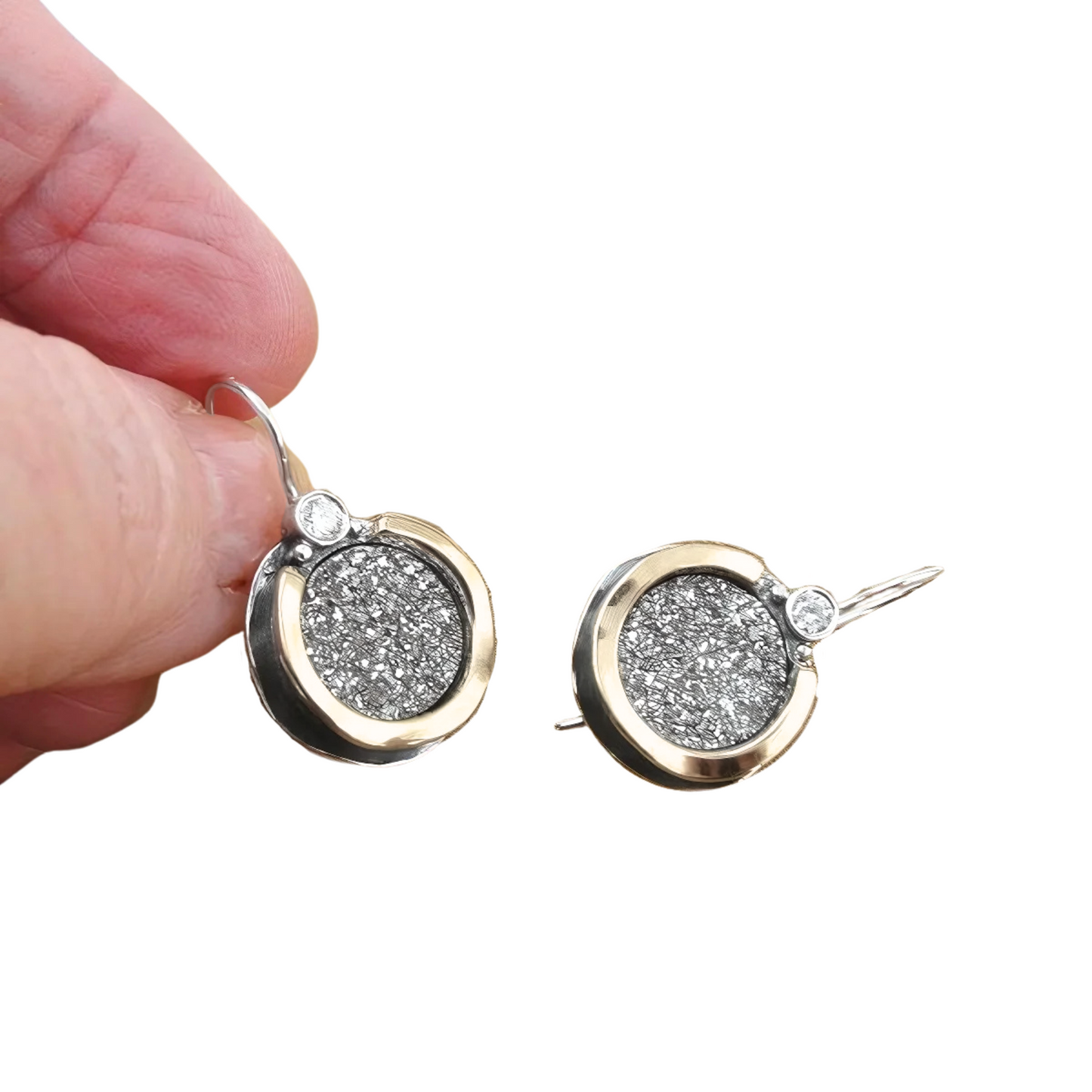 Elegant handmade sterling silver earrings featuring shimmering druzy gemstones set in a unique 9K yellow gold frame with clear zircon accents. These artisan-designed earrings by Hadar Jewelry combine the sparkle of druzy with the sophistication of gold and silver, creating a timeless piece perfect for both daily elegance and special occasions. The round shape and luxurious materials make these earrings an ideal statement accessory for those who appreciate fine, handcrafted jewelry.