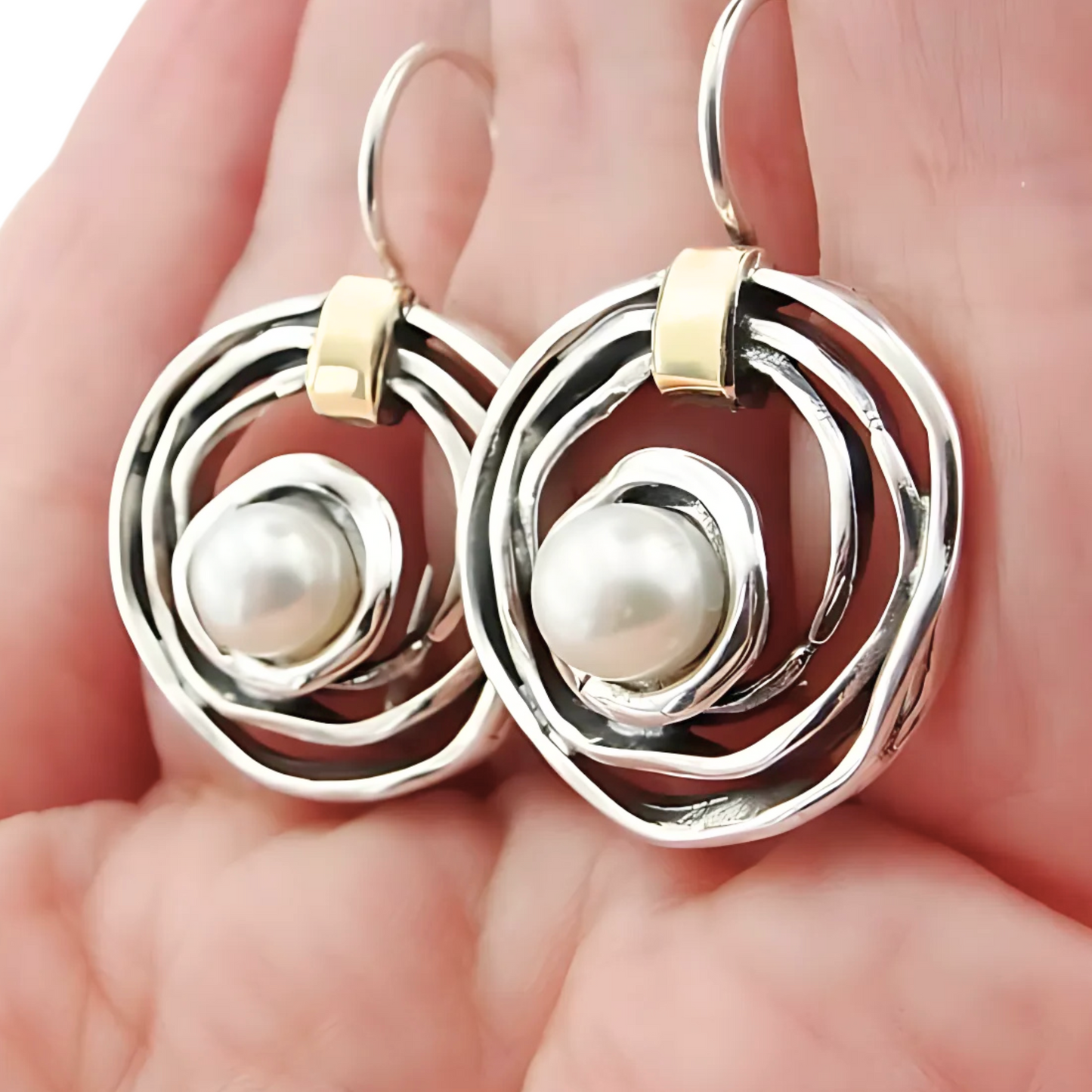 Elegant, handcrafted sterling silver earrings with a sophisticated open spiral design, featuring lustrous freshwater pearls as centerpieces and accented with delicate touches of yellow gold. These unique earrings, designed by Hadar Jewelry, blend modern aesthetics with timeless luxury, perfect for adding a refined, statement look to any ensemble.