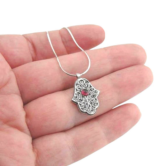 Sterling silver Hamsa pendant with intricate design and a natural garnet at the center, symbolizing protection and good luck. A meaningful and spiritual piece of jewelry, perfect for a gift and adding positive energy.