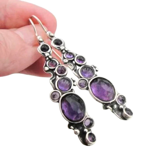 Elegant sterling silver earrings with natural amethyst stones, featuring one oval and six round gemstones. A perfect, meaningful Christmas gift, adding sophistication and charm to any occasion