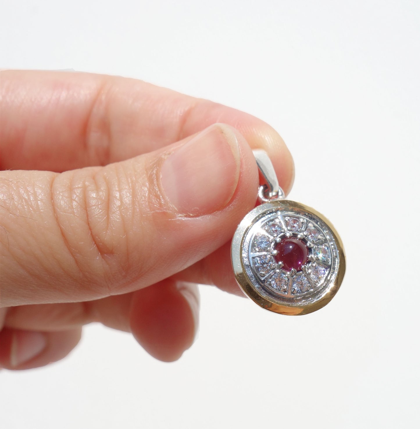 Gold decorated with white Zircon inlaid, sterling silver, and Garnet Gemstone. Arrive with Sterling silver