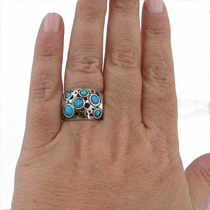 Sterling silver wide ring with blue opal dots.