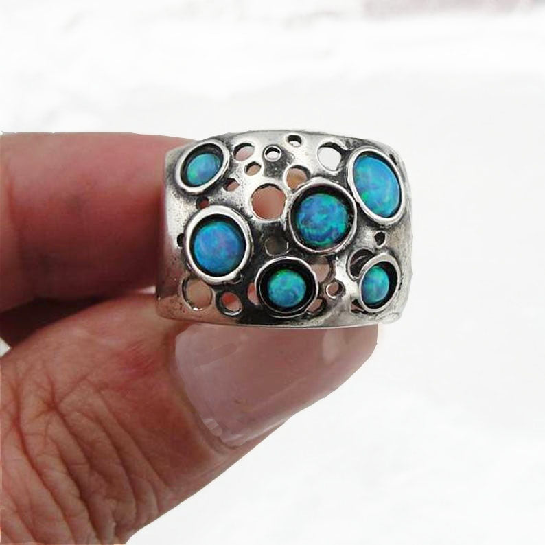 Sterling silver wide ring with blue opal dots.