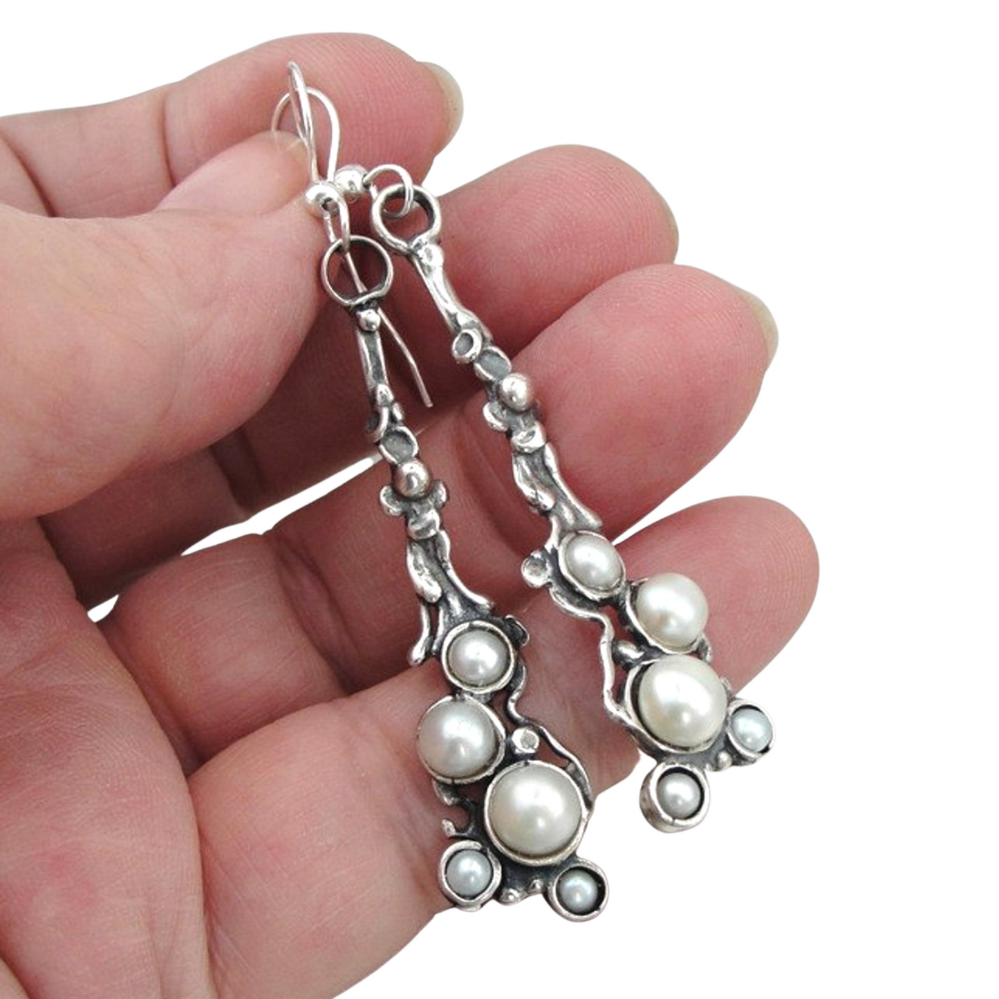 Long sterling silver earrings decorated with white natural pearls.
